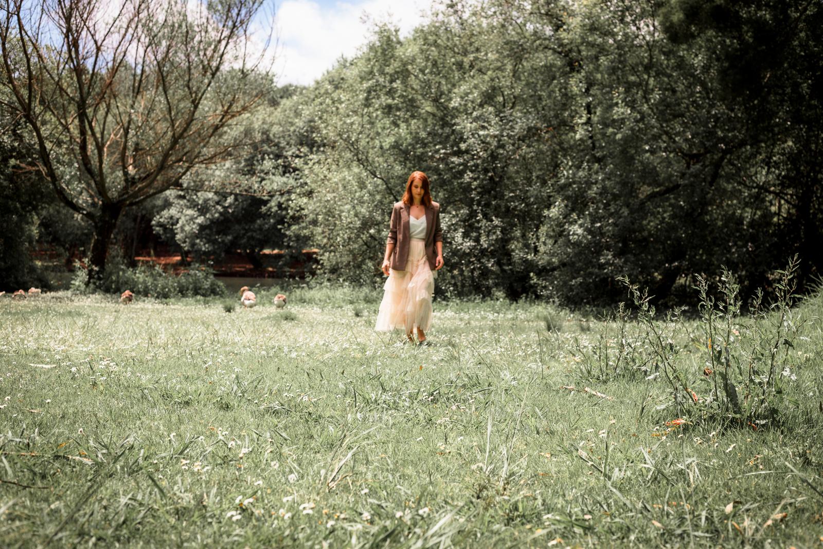 Paula a caminhar num espaço verde, rodeada pela natureza